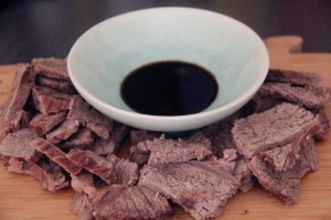 a bowl of soy sauce surrounded by boiled beef