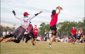 Players Reach for Frisbee in Game of Ultimate Frisbee