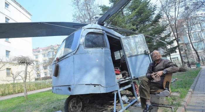 old man sitting next to his home-made helicopter in china