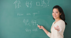 teacher teaching chinese characters on a chalk board