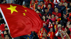 Chinese fans celebrate a goal with the national flag